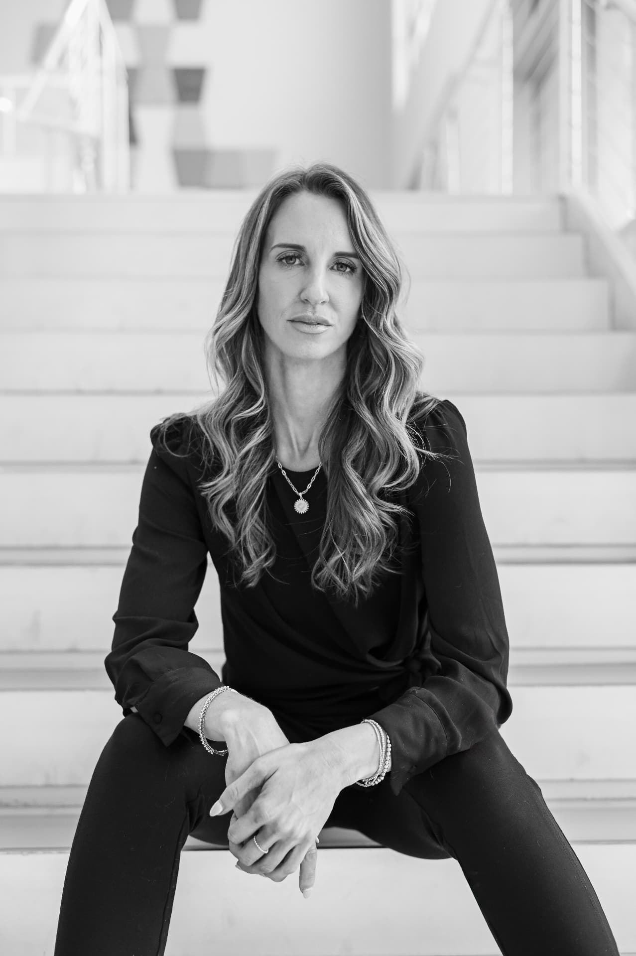 Lowcountry branding photographer — black and white headshot of a businesswoman seated on bright white stairs