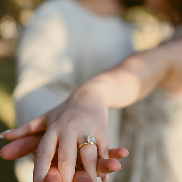 Close detail of a couple's hands and engagement ring